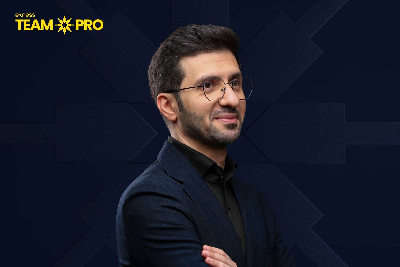 Portrait of a man in a navy suit with glasses, arms crossed, against a dark geometric background with the Exness Team Pro logo.